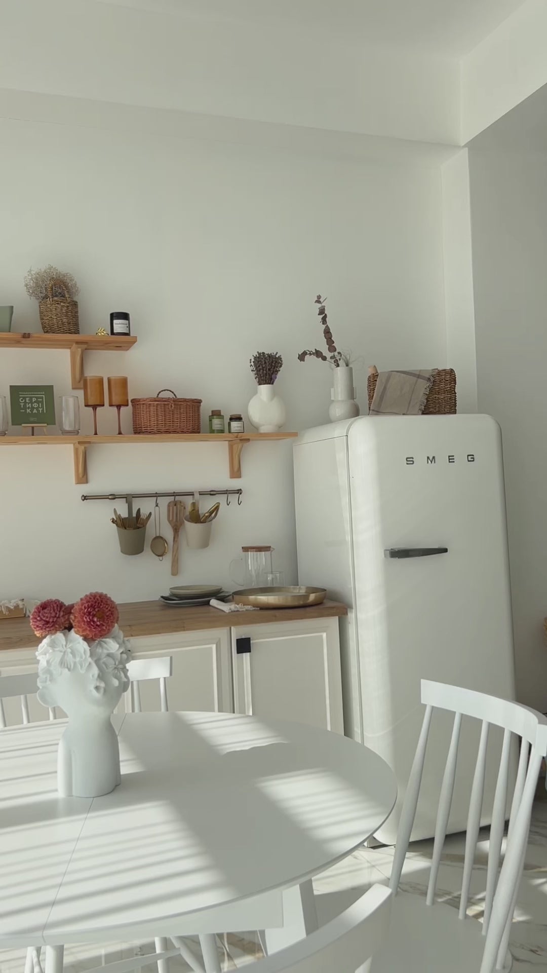 White extendable round dining table with white Windsor dining chairs